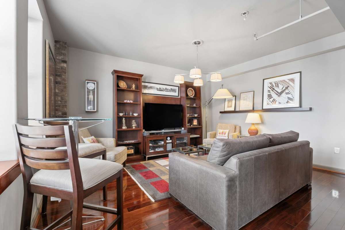 The condo features a spacious living room with updated hardwood floors throughout.