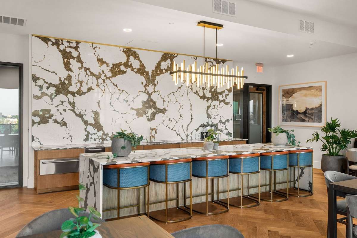 The Terrace Lounge is one of several entertainment spaces, offering a bar area with self-serve wine and beer taps and cozy seating. It seamlessly opens to the poolside deck, complete with a firepit, grilling stations, and outdoor TVs.