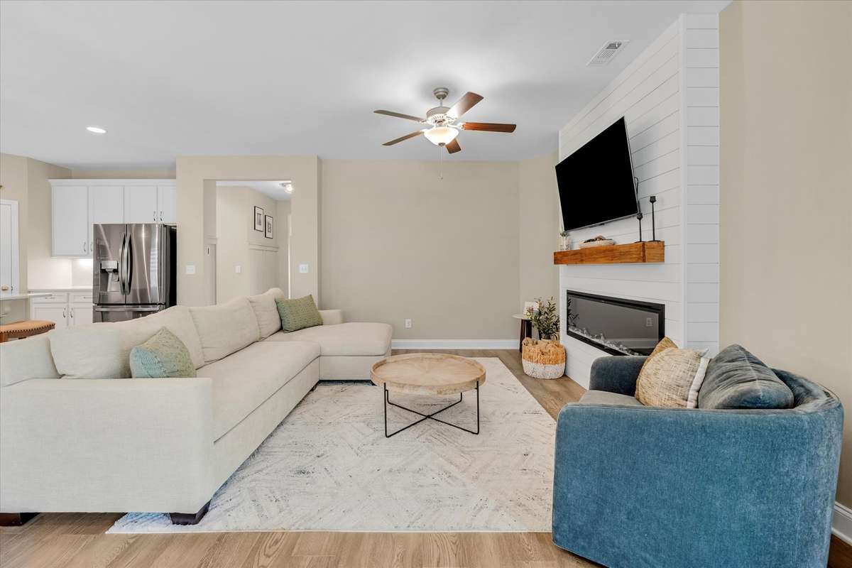 Custom shiplap accent wall with electric fireplace really sets this family room apart.