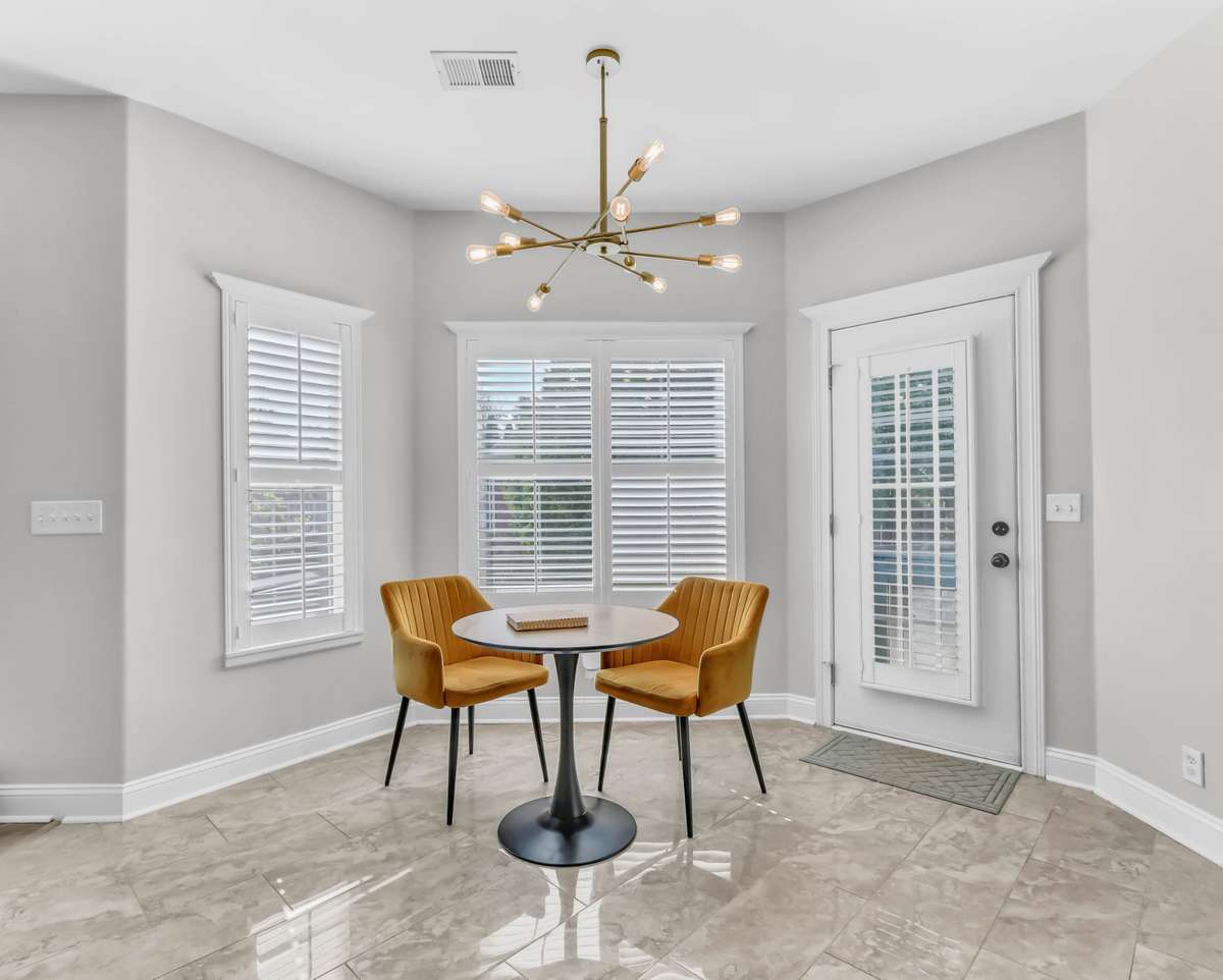 The eat-in area in the kitchen with plenty of natural light + modern lighting.