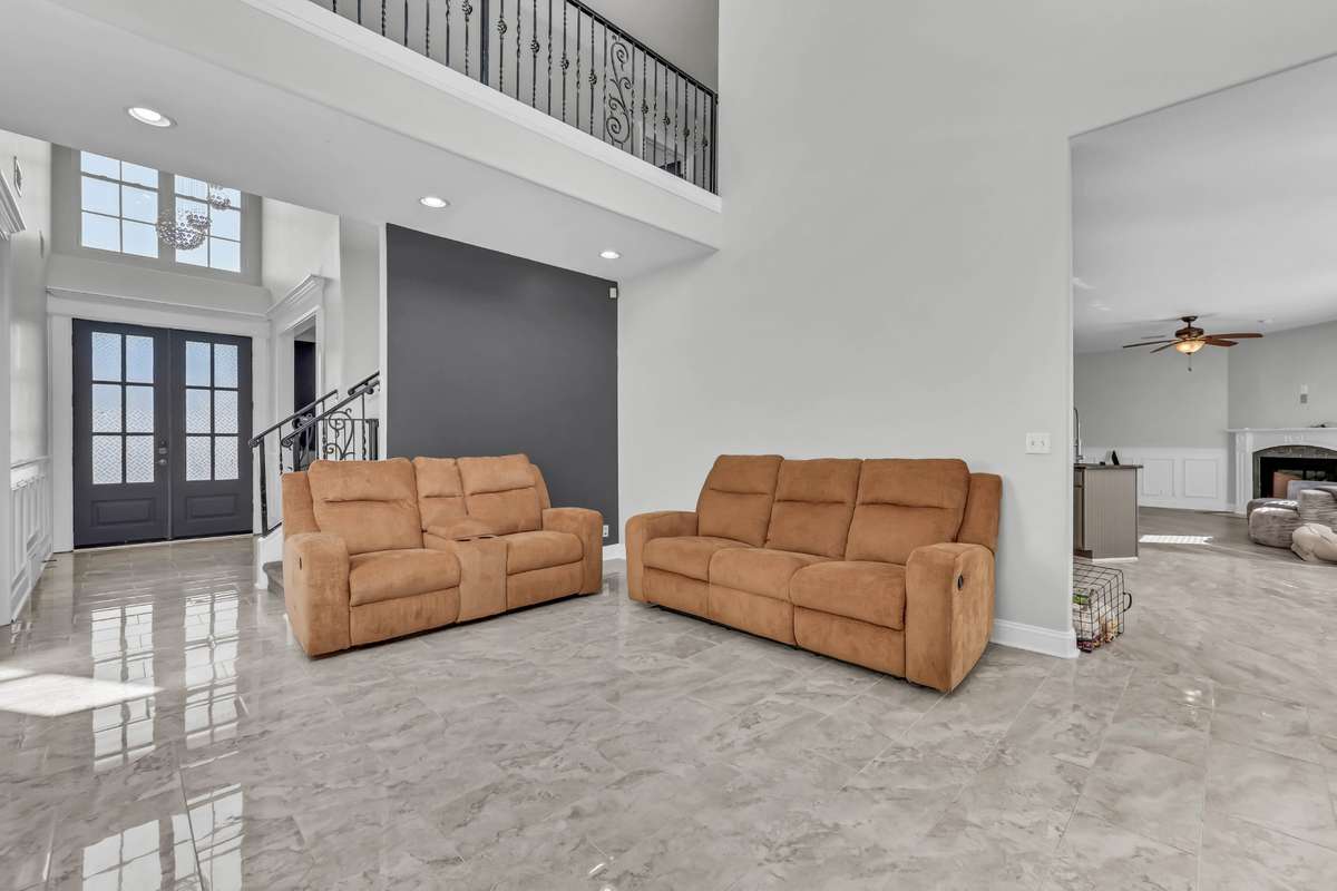 The formal living room features soaring ceilings + natural light.