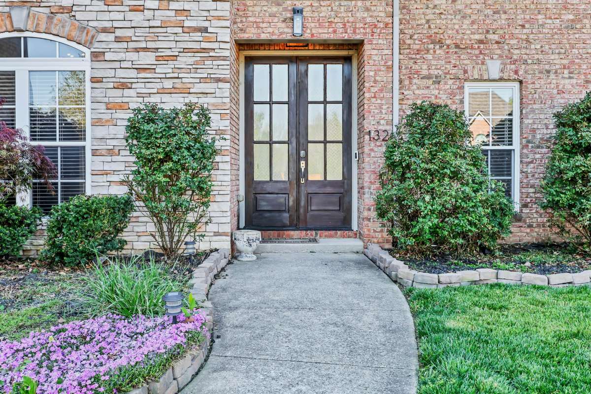 The grand entry doors greet you under the covered porch.