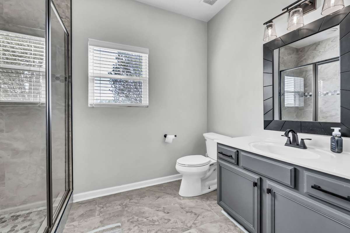 The full bath in the second primary bedroom includes an oversized walk in shower.