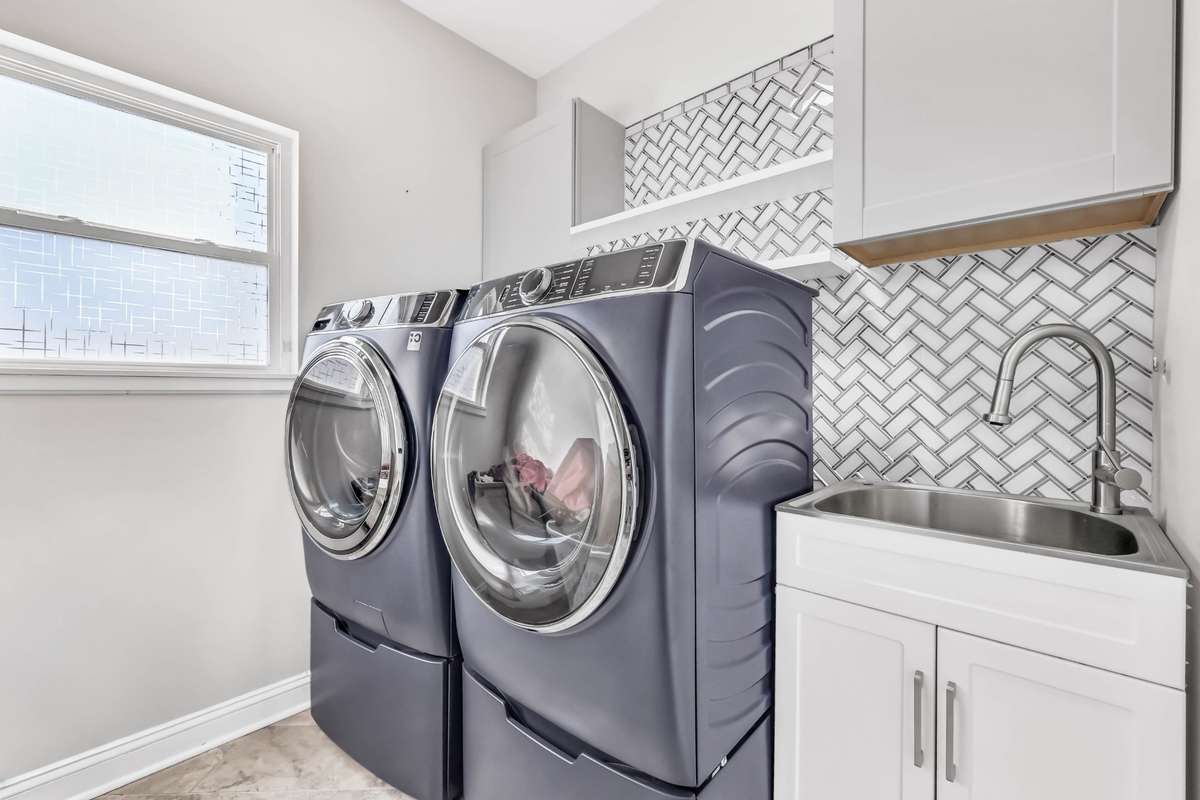 The laundry room does not disappoint. Spacious + tile backsplash + wash sink.