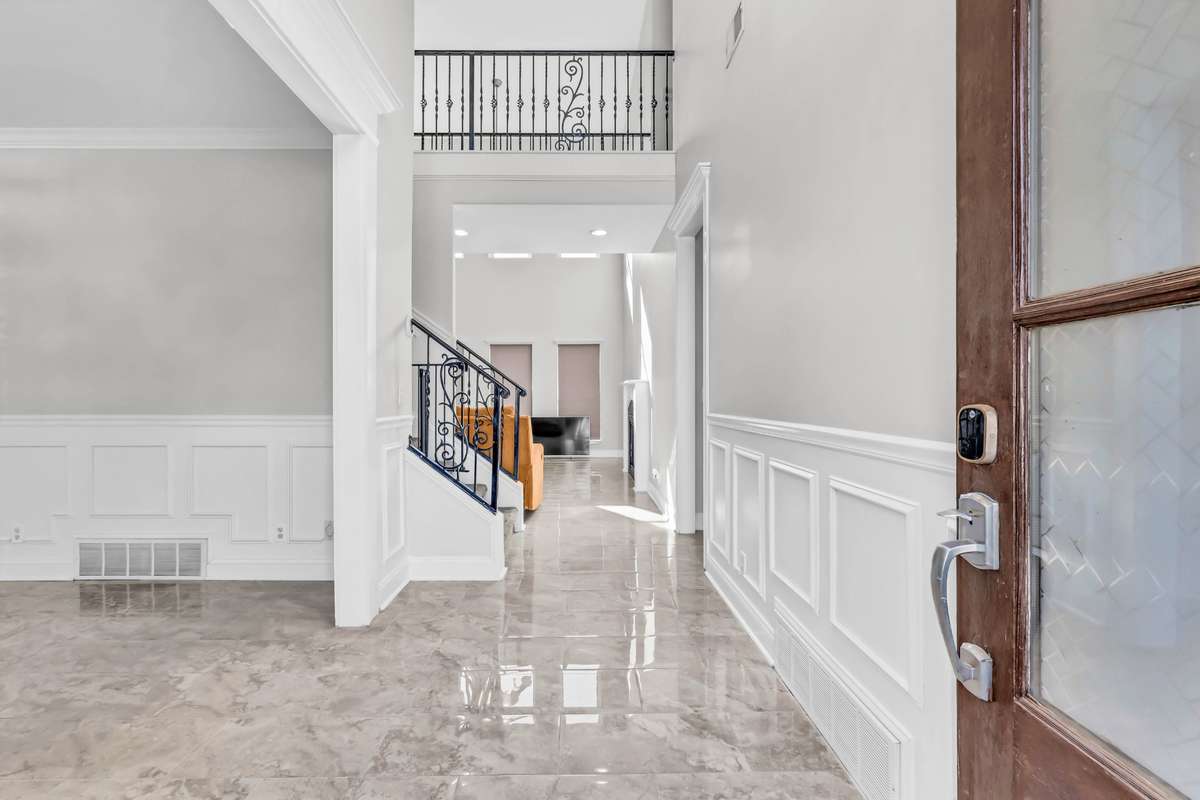 Step inside to a two-story entry foyer with tile flooring & modern lighting.
