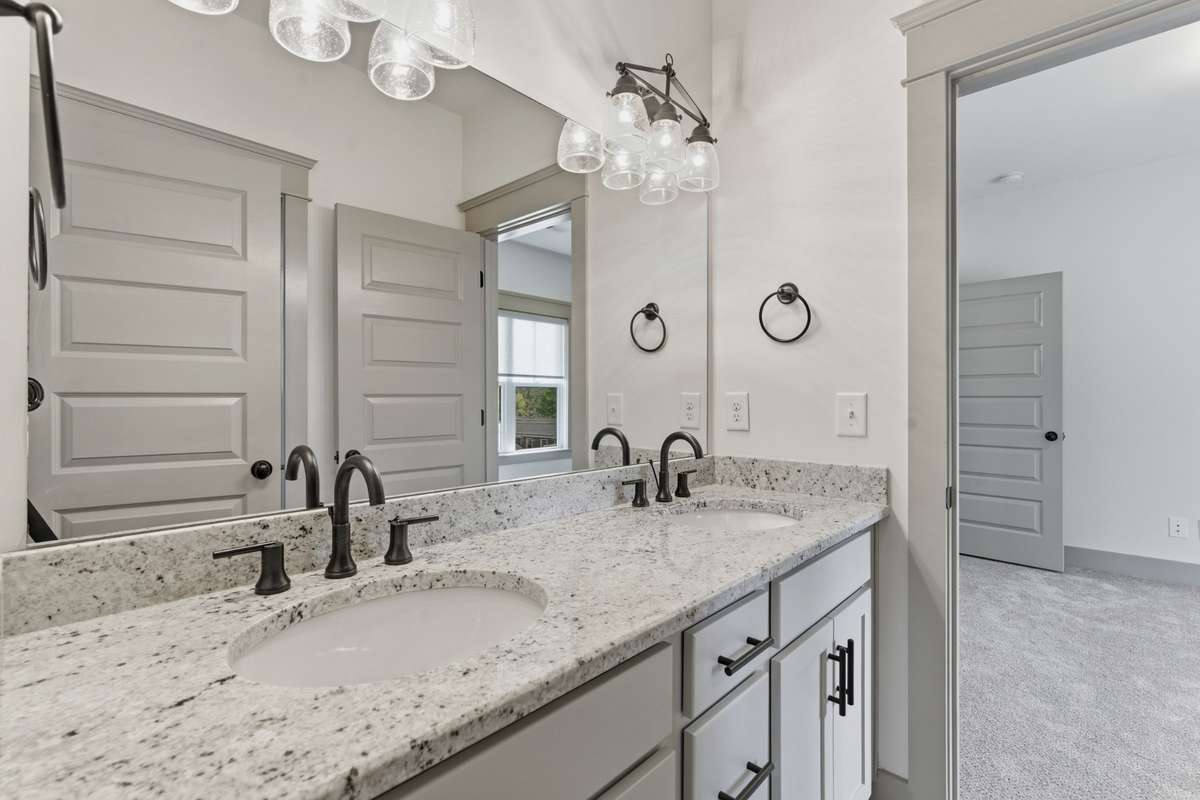 Double vanities in full bathroom connecting the secondary and tertiary bedrooms