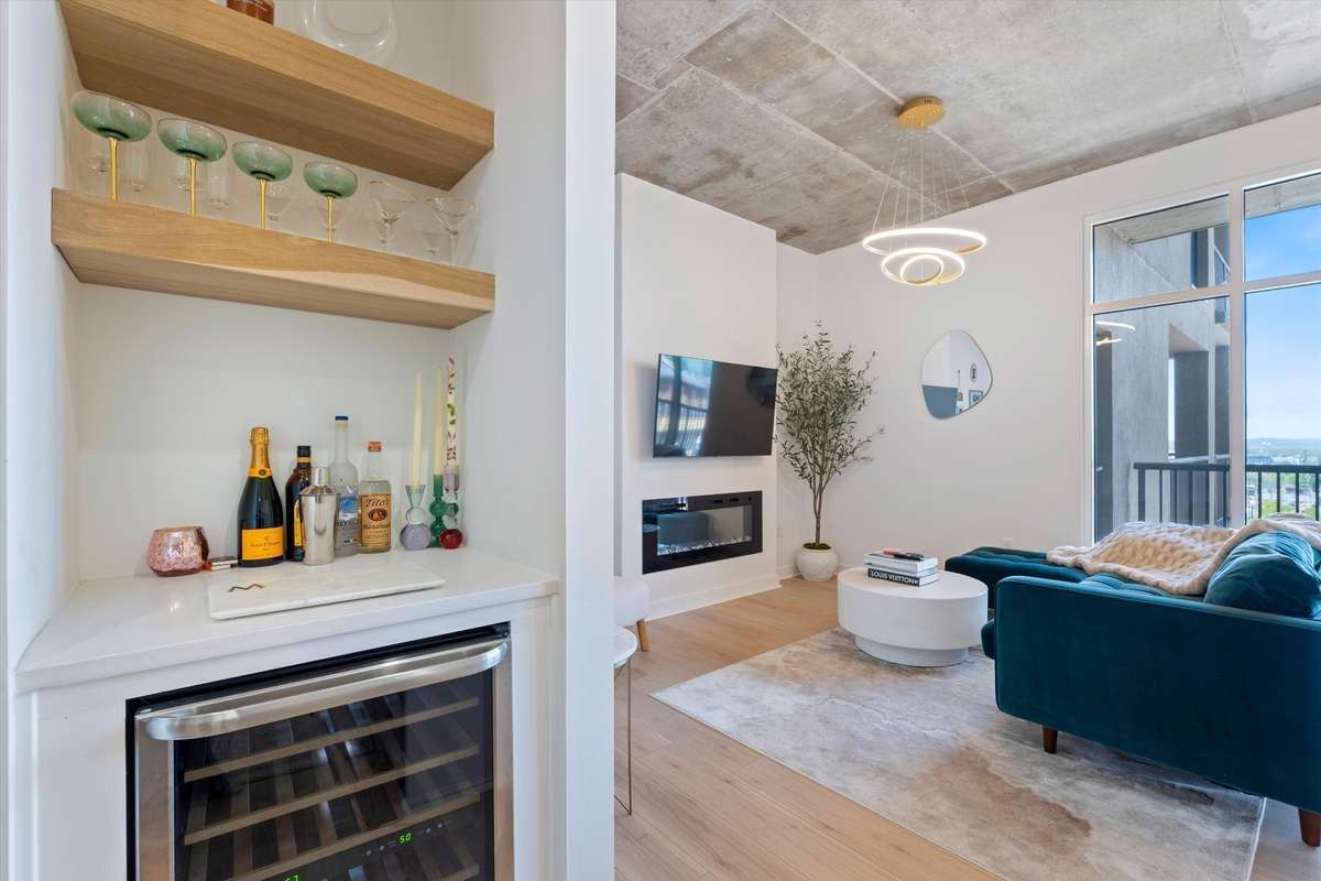 Custom beverage nook with floating oak shelving and stainless wine cooler