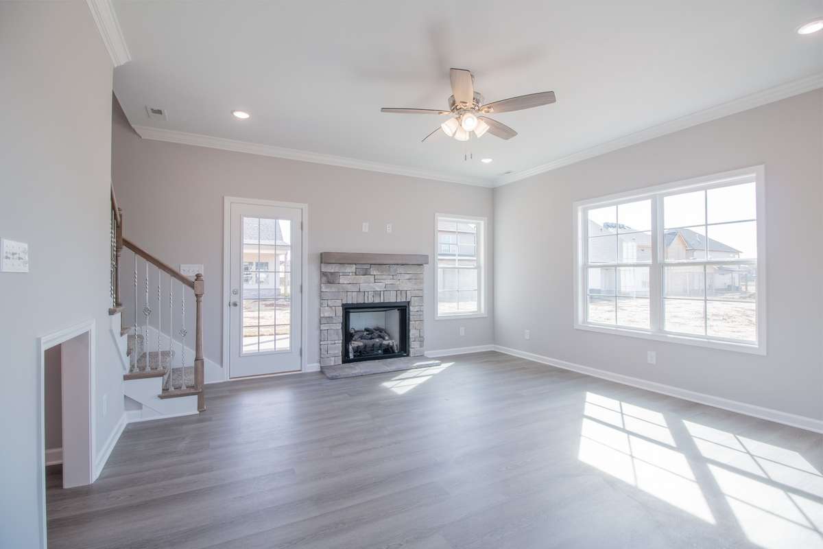 EXAMPLE>>>Large Living Room with a Stone Fireplace, Floating Wood Mantle, Crown Molding, Tons of Natural Lighting and Access to the Large Covered Patio!