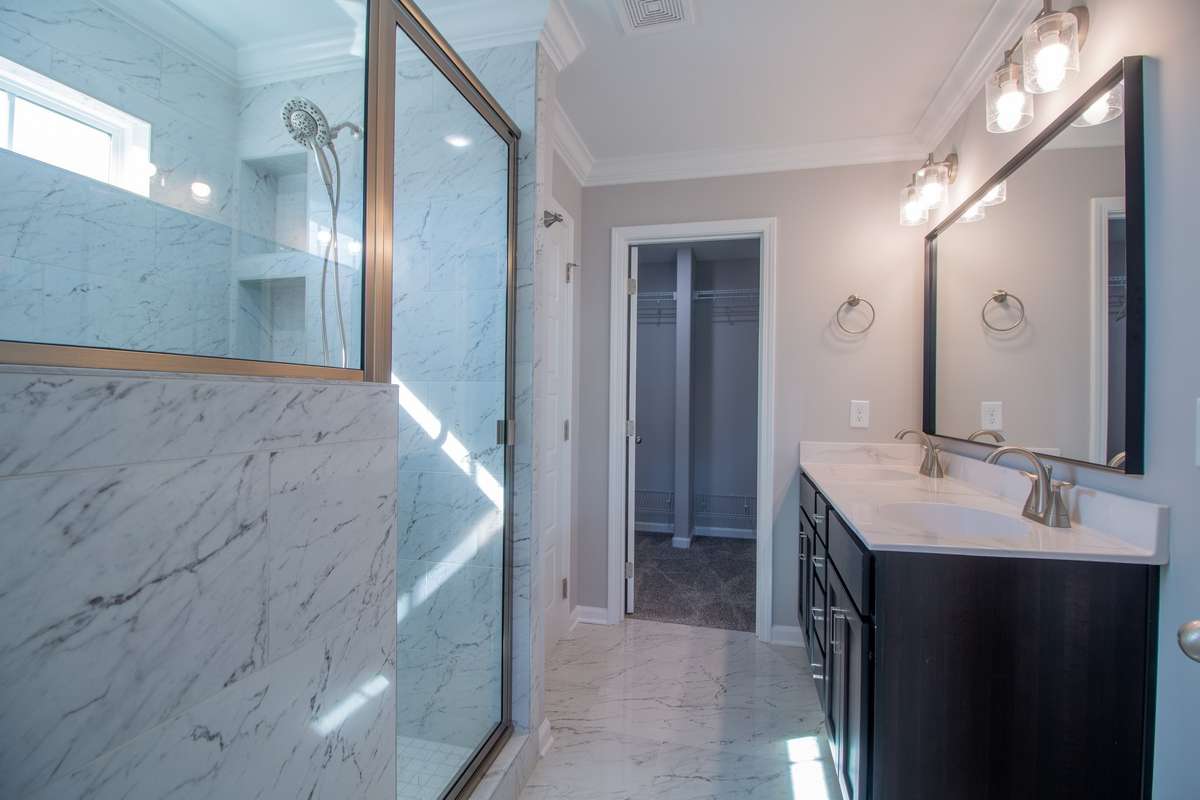 EXAMPLE>>>Primary Bathroom with Tile Flooring, Crown Molding, a Double Vanity, Tile Shower, Walk-in Closet and a Toilet Room!