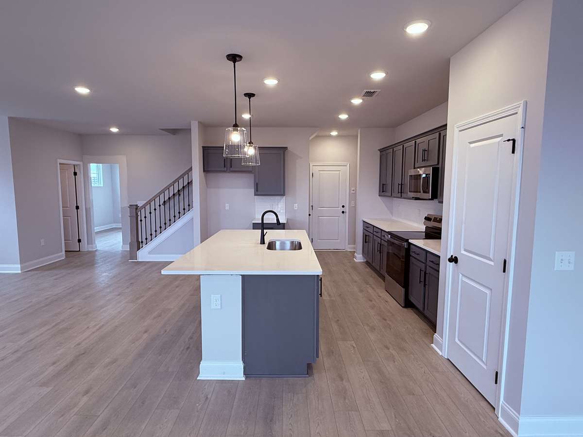 The home is complete with black fixtures, stainless steel appliances, and stylish pendant lighting — thoughtfully selected to enhance the kitchen’s modern design and functionality.