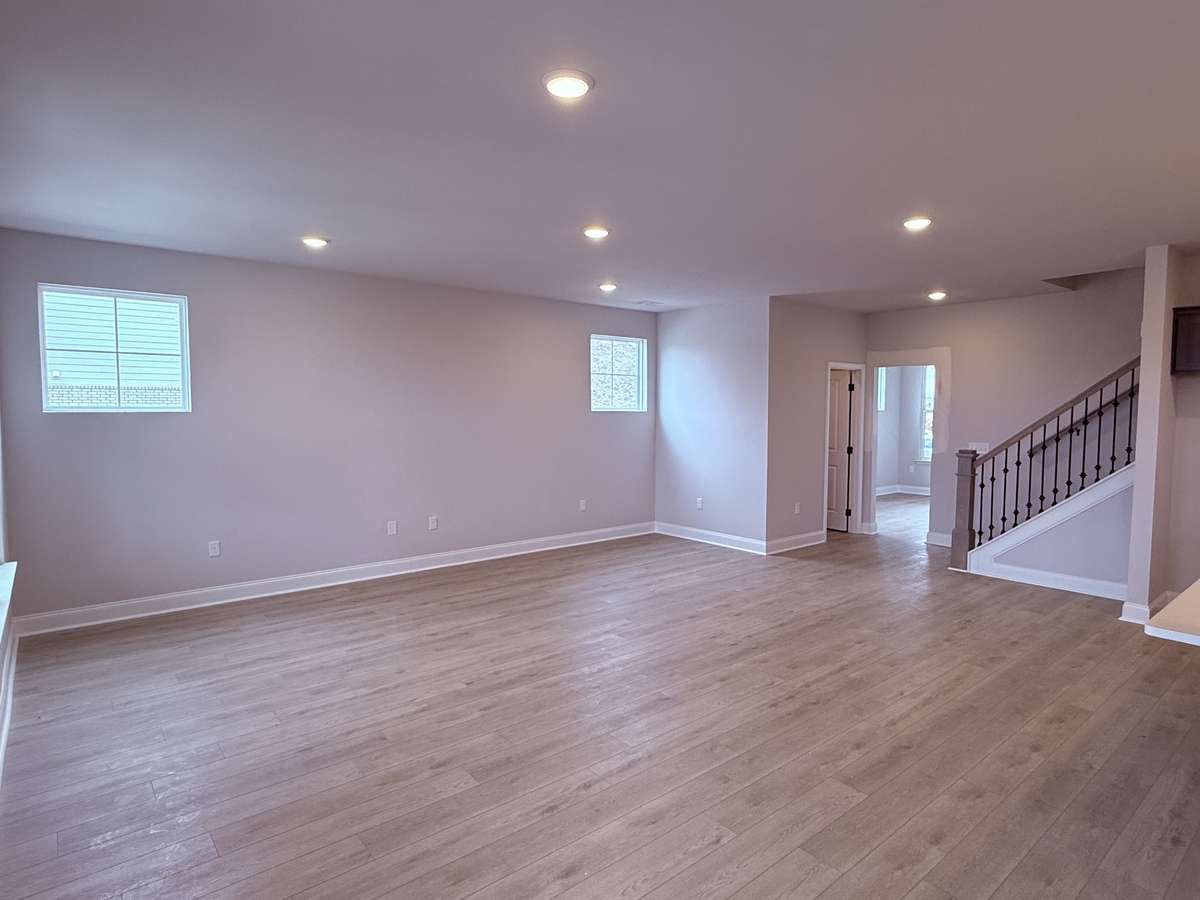 The great room is impressively spacious, designed to accommodate both everyday living and large gatherings. Its abundant natural light streams through generous windows, creating a bright and inviting atmosphere.