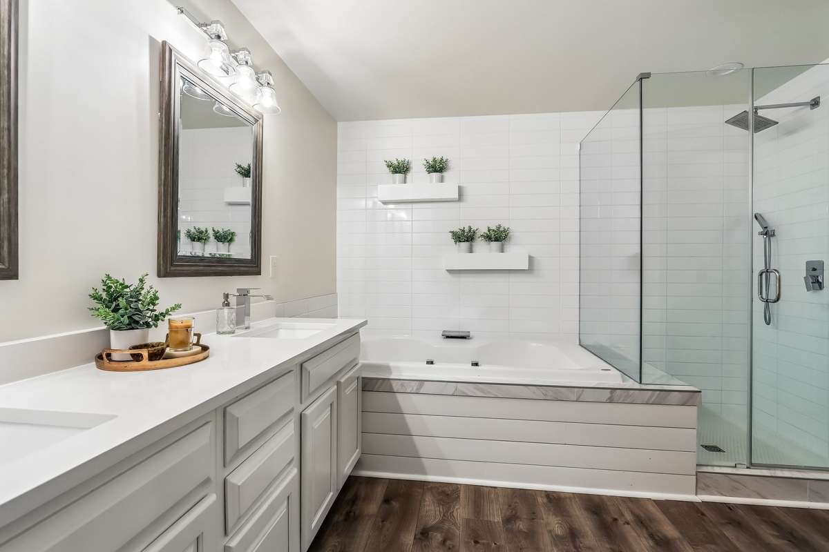 Renovated primary bathroom featuring a soaking tub and walk-in shower.