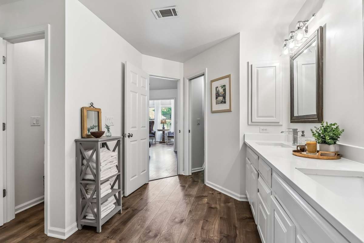 Dual sinks in primary bathroom with separate toilet room.