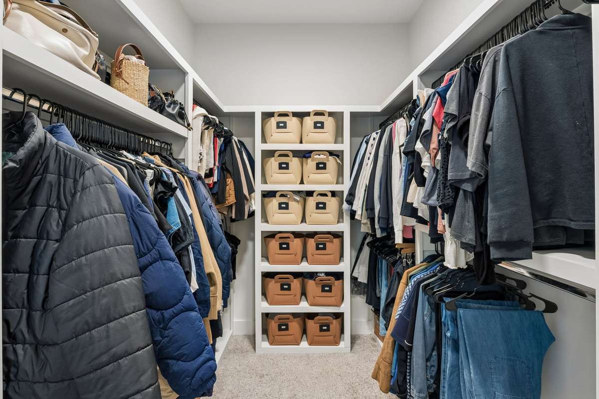 Spacious walk-in closet with built-in wood shelving