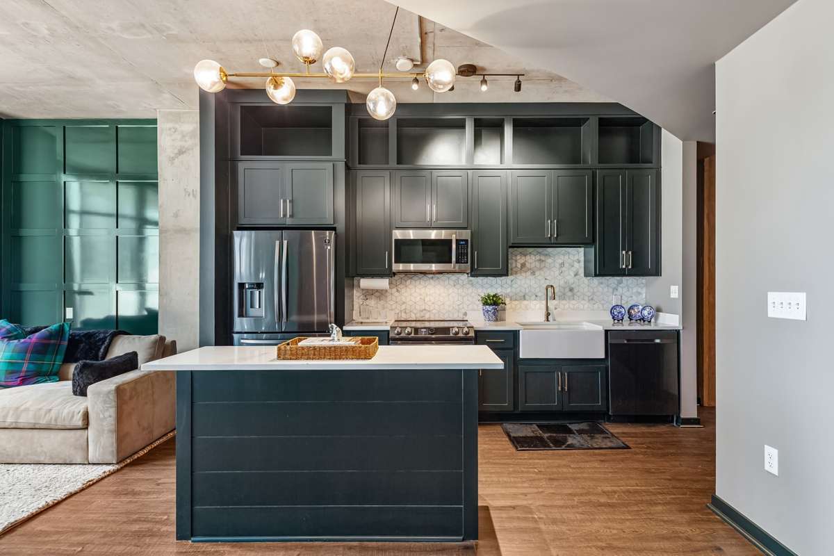 Freshly painted cabinetry, stainless steel appliances, a farmhouse sink, marble backsplash, and a spacious island with storage come together to create a stunning, functional kitchen designed for both everyday living and entertaining.