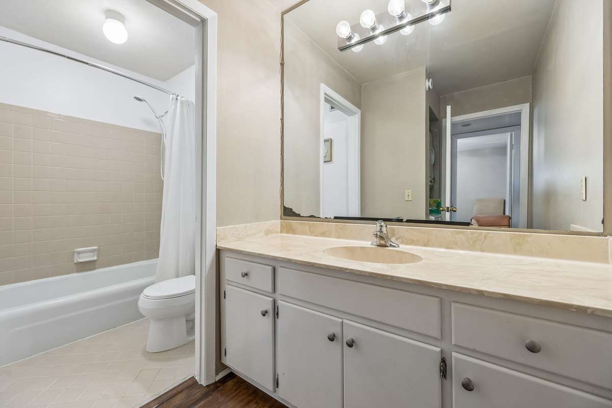 Gorgeous updated full bath with new tile, large vanity area and private tub/shower and commode  area.