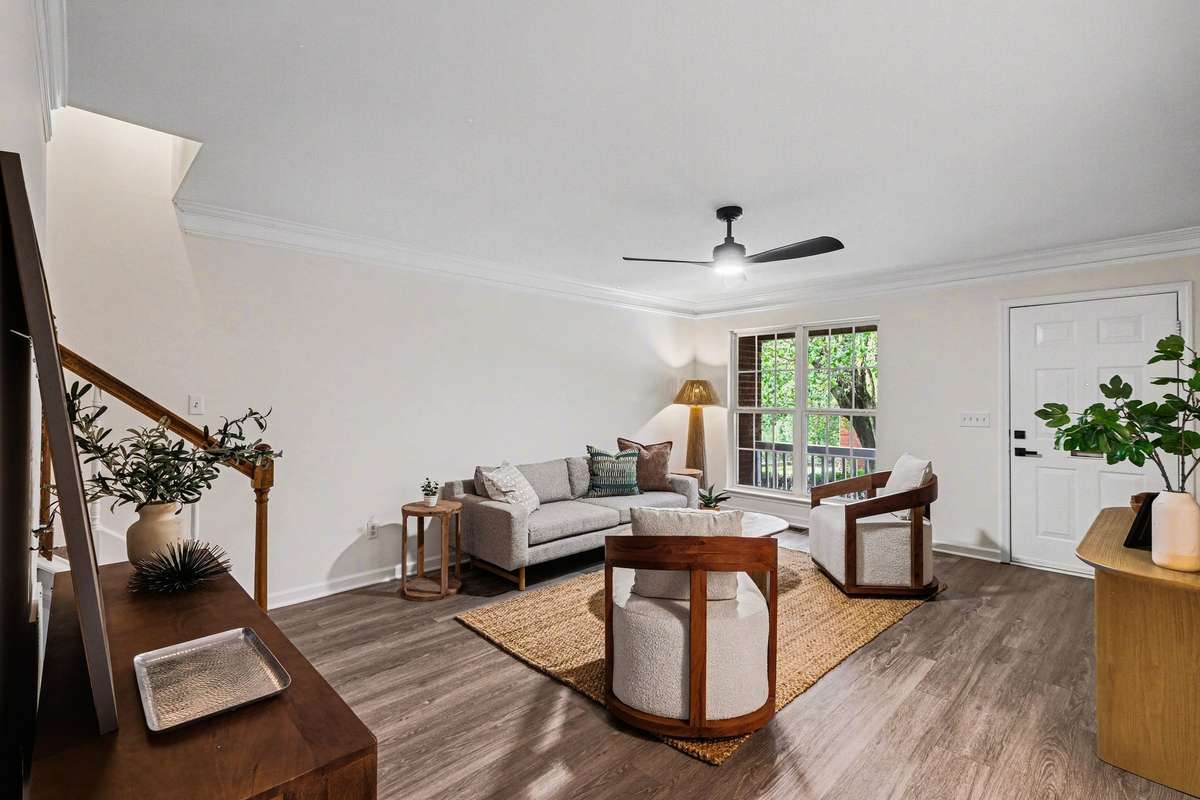 The spacious living area features fresh interior paint, updated modern flooring, and a stylish new ceiling fan. Large windows provide plenty of natural light, creating a bright and airy atmosphere perfect for relaxing or entertaining.