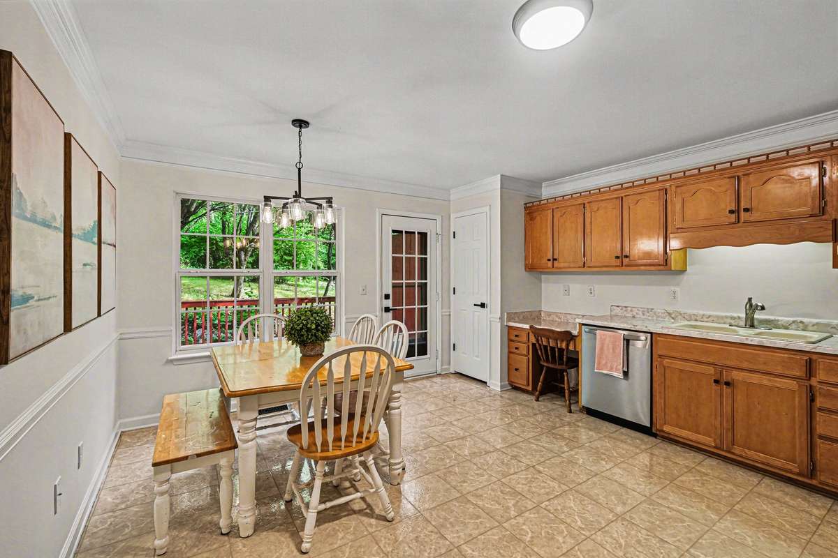 Bright kitchen and dining combo featuring new appliances, updated fixtures, and a built-in workspace. The glass-paneled door leads to a private outdoor deck, making indoor-outdoor living a breeze.