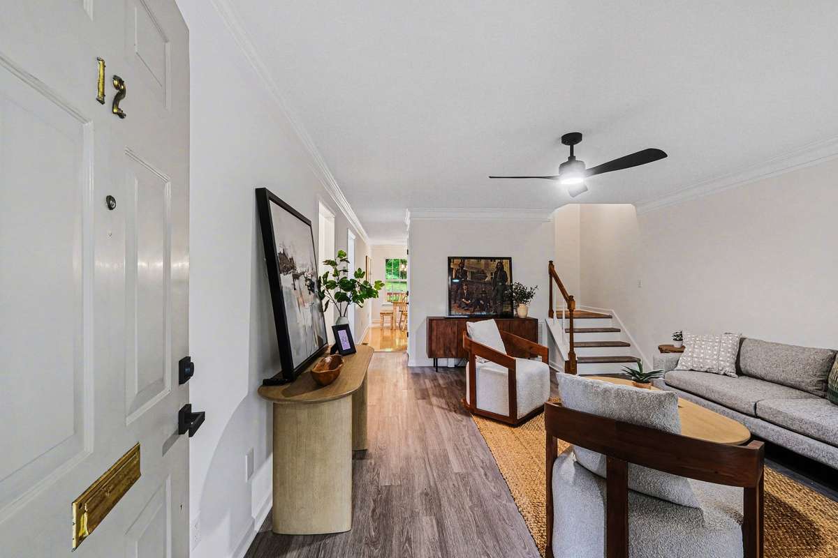The welcoming entryway opens into a spacious living area that flows seamlessly toward the kitchen and dining space. This move-in-ready layout is accented by stylish new light fixtures and a crisp, neutral color palette.