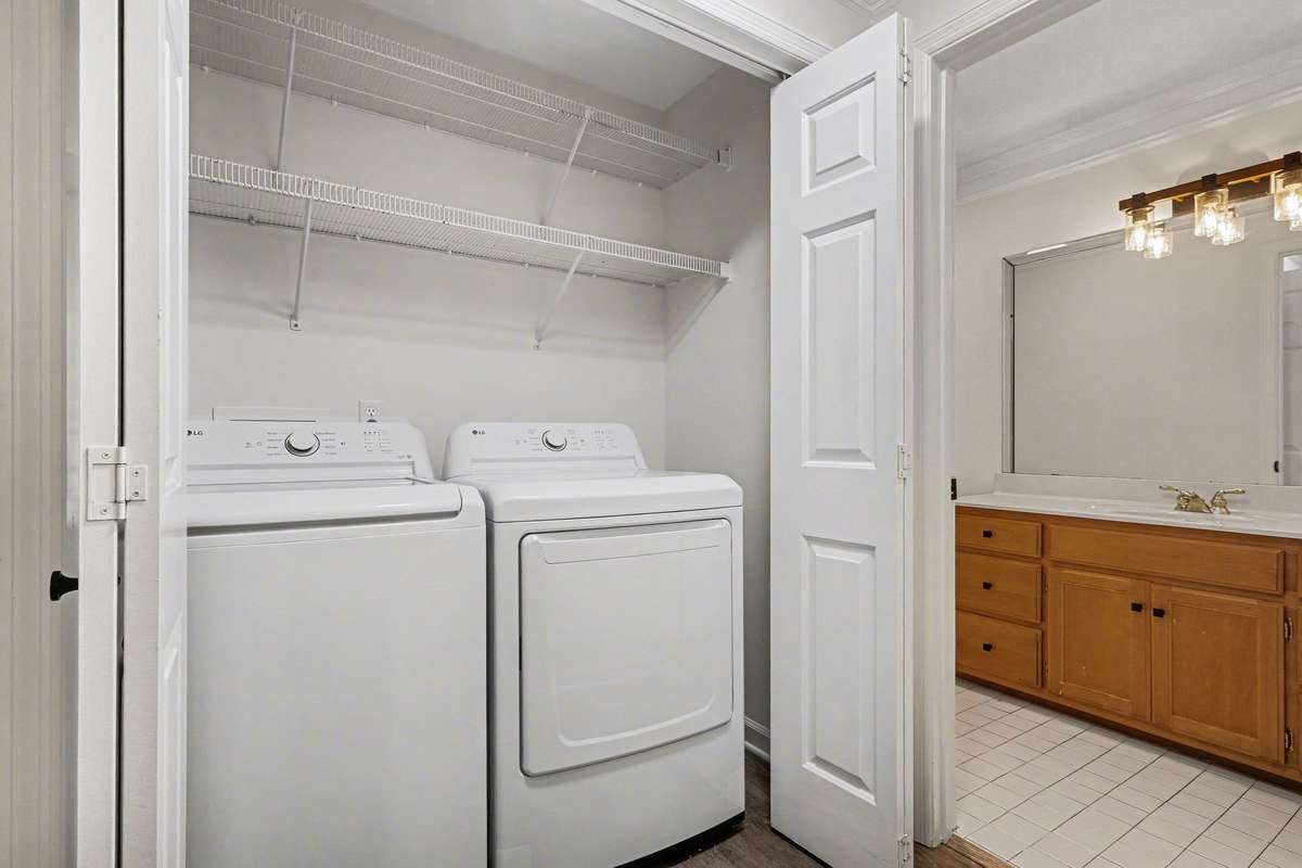 Enjoy the ease of main-level laundry! Tucked away behind classic bi-fold doors with updated hardware, this space includes extra shelving for storage and is perfectly positioned to serve the entire home efficiently.