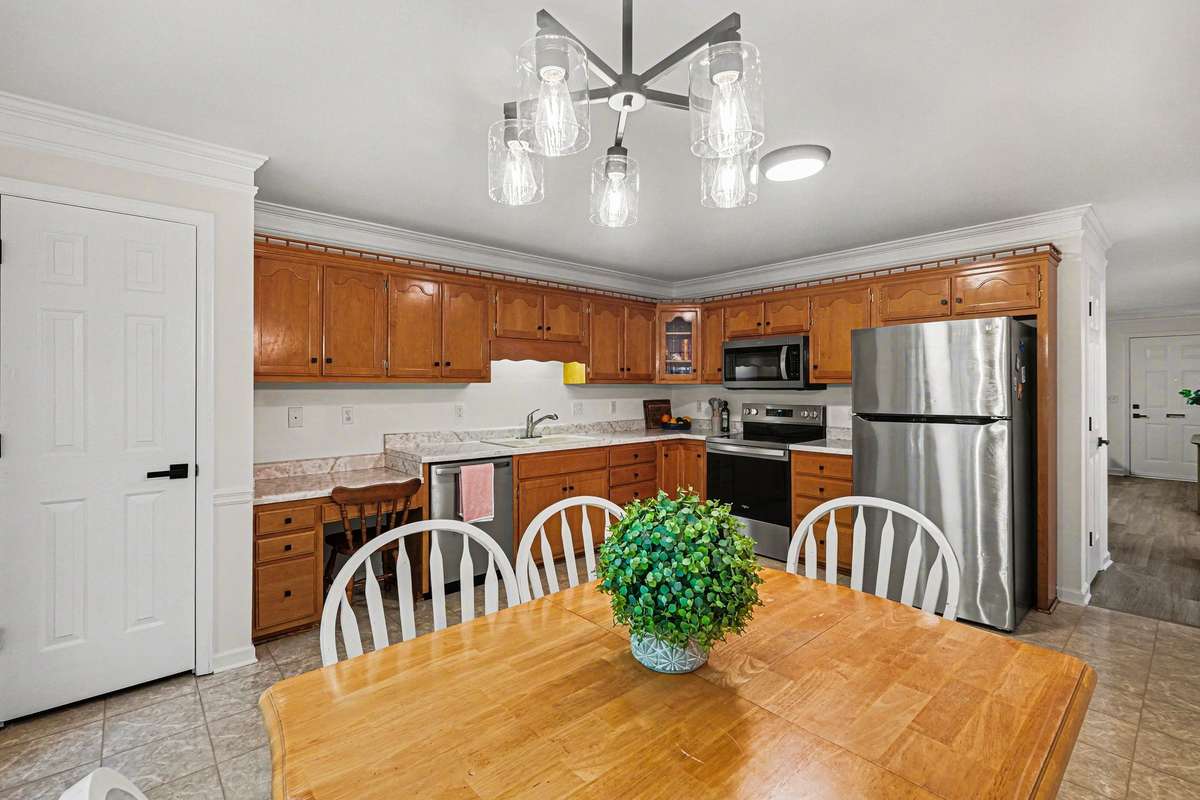 The kitchen shines with a brand-new stainless steel appliance package! This functional space also features a stylish new chandelier, crisp crown molding, and a built-in desk area—perfect for a home office nook or coffee station.