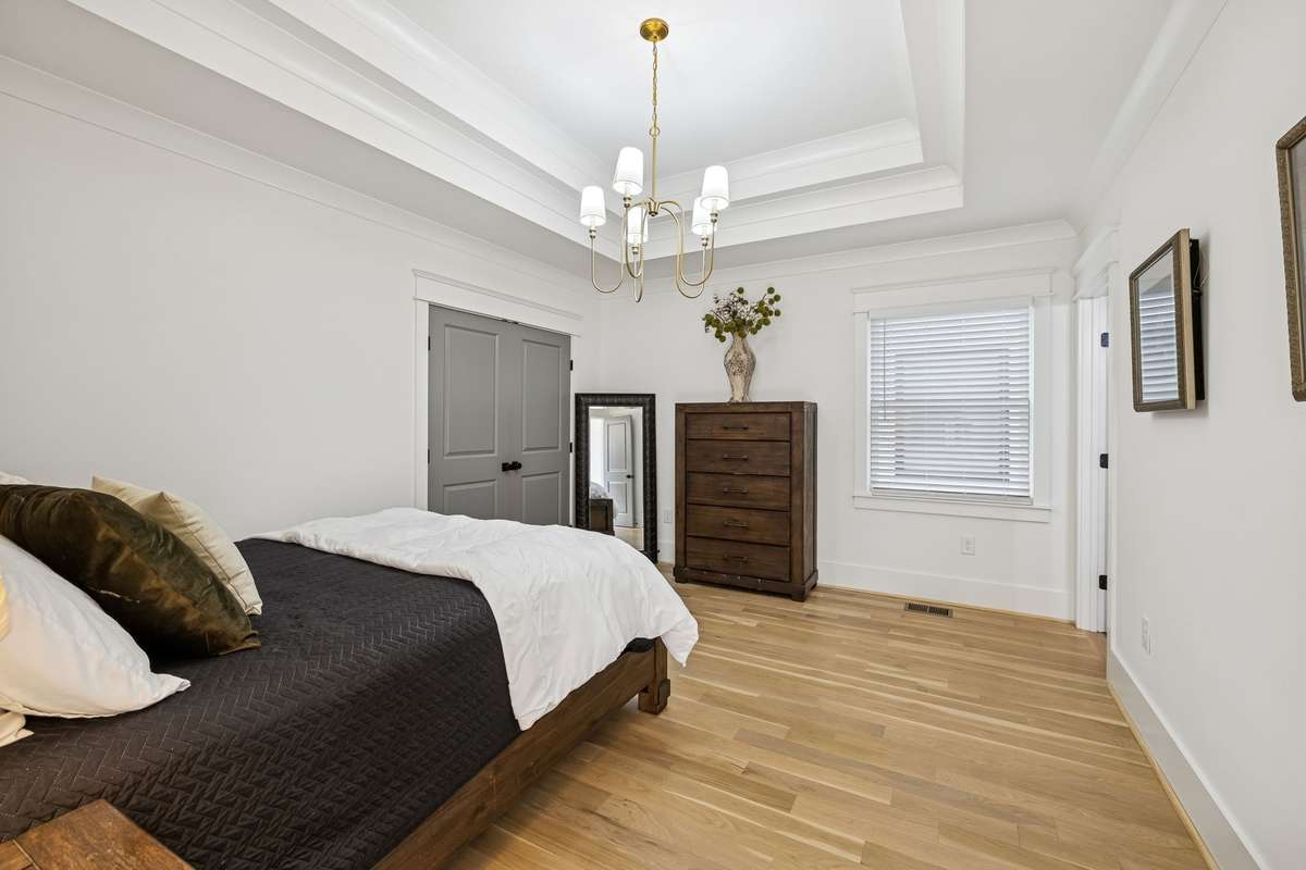 Private guest ensuite bedroom with tray ceiling on main level