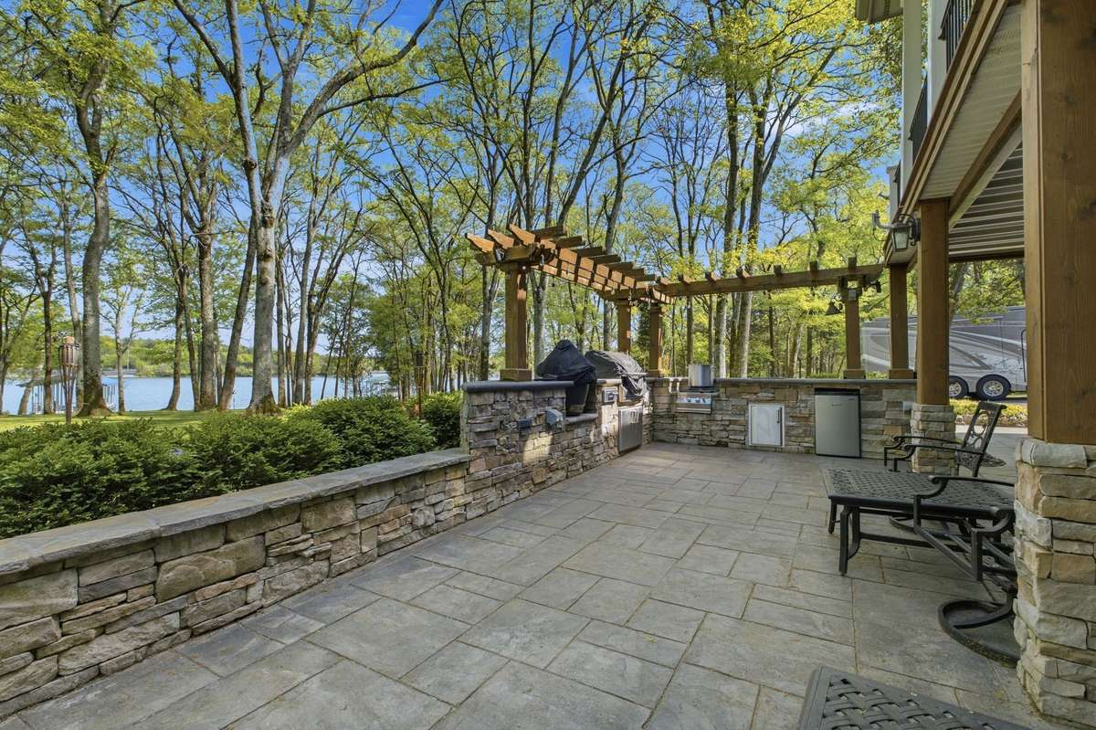 The outdoor kitchen has a sink, mini-fridge, gas grill and a green egg grill. There is tons of room for seating.