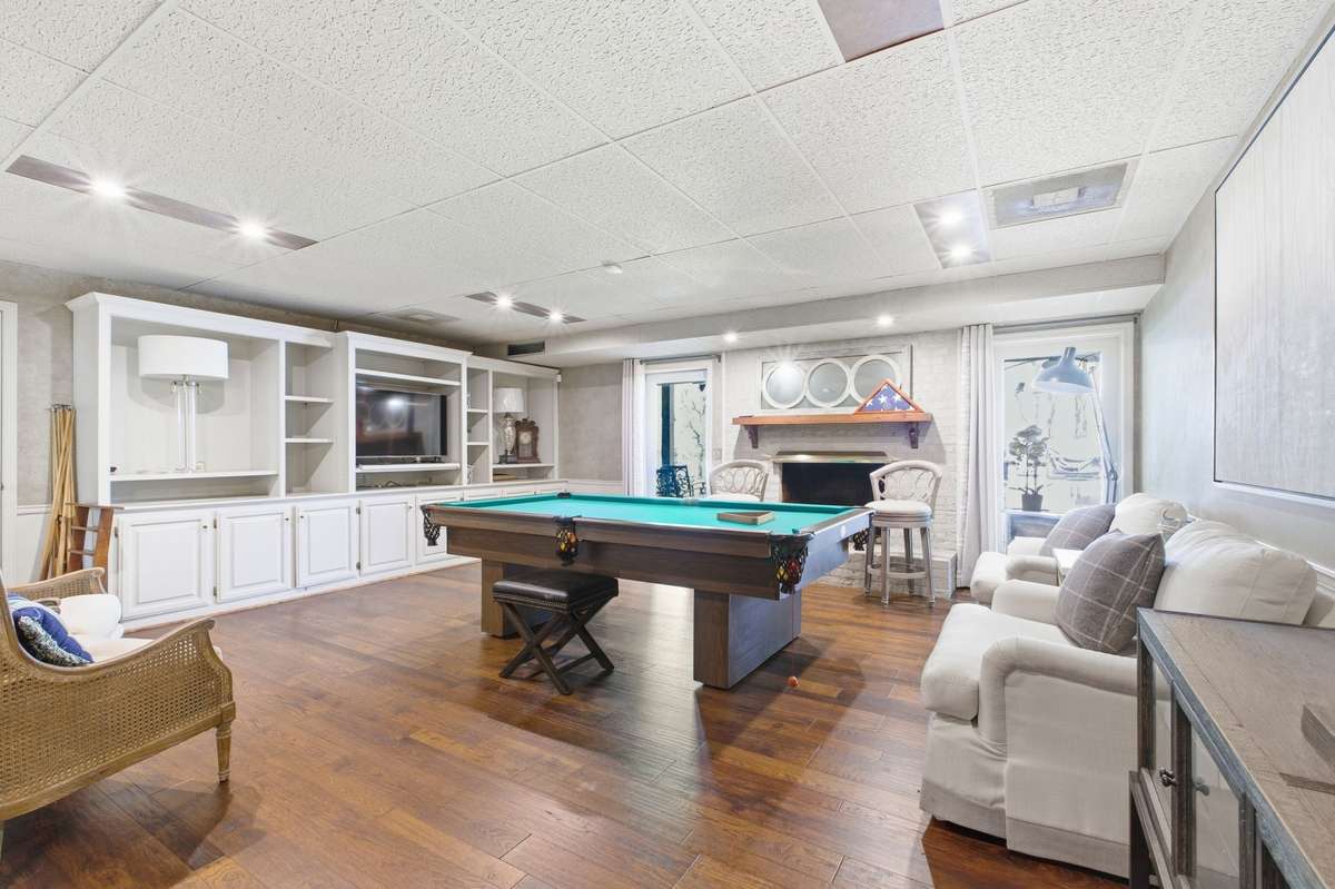 This is the finished area of the basement. It has built-in shelving, hardwood floors and a full bathroom. There is access to the lower patio area, and the garages.
