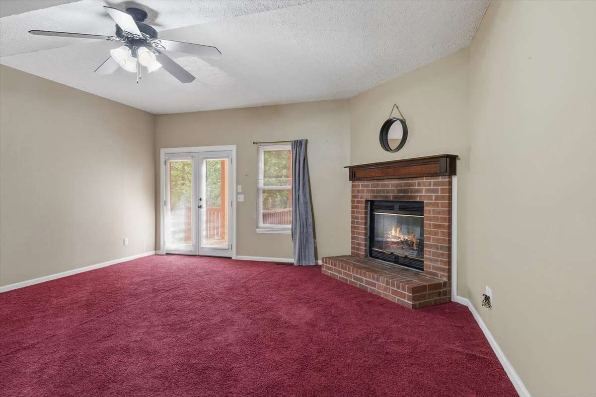 Large Basement living room/rec room space with gas and wood burning fireplace. Tall ceilings.