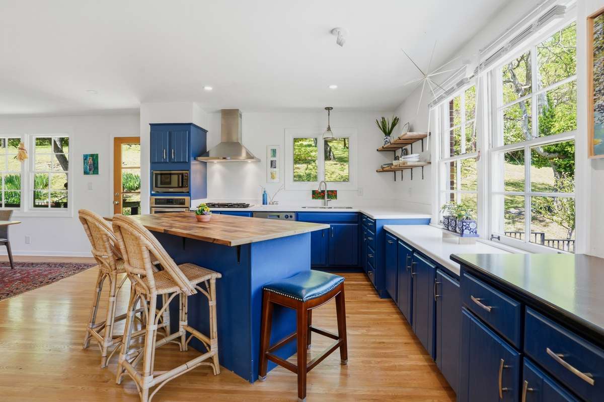 Large, open kitchen with stainless appliances, tons of natural light, beverage refrigerator, eat-in island and open to dining.