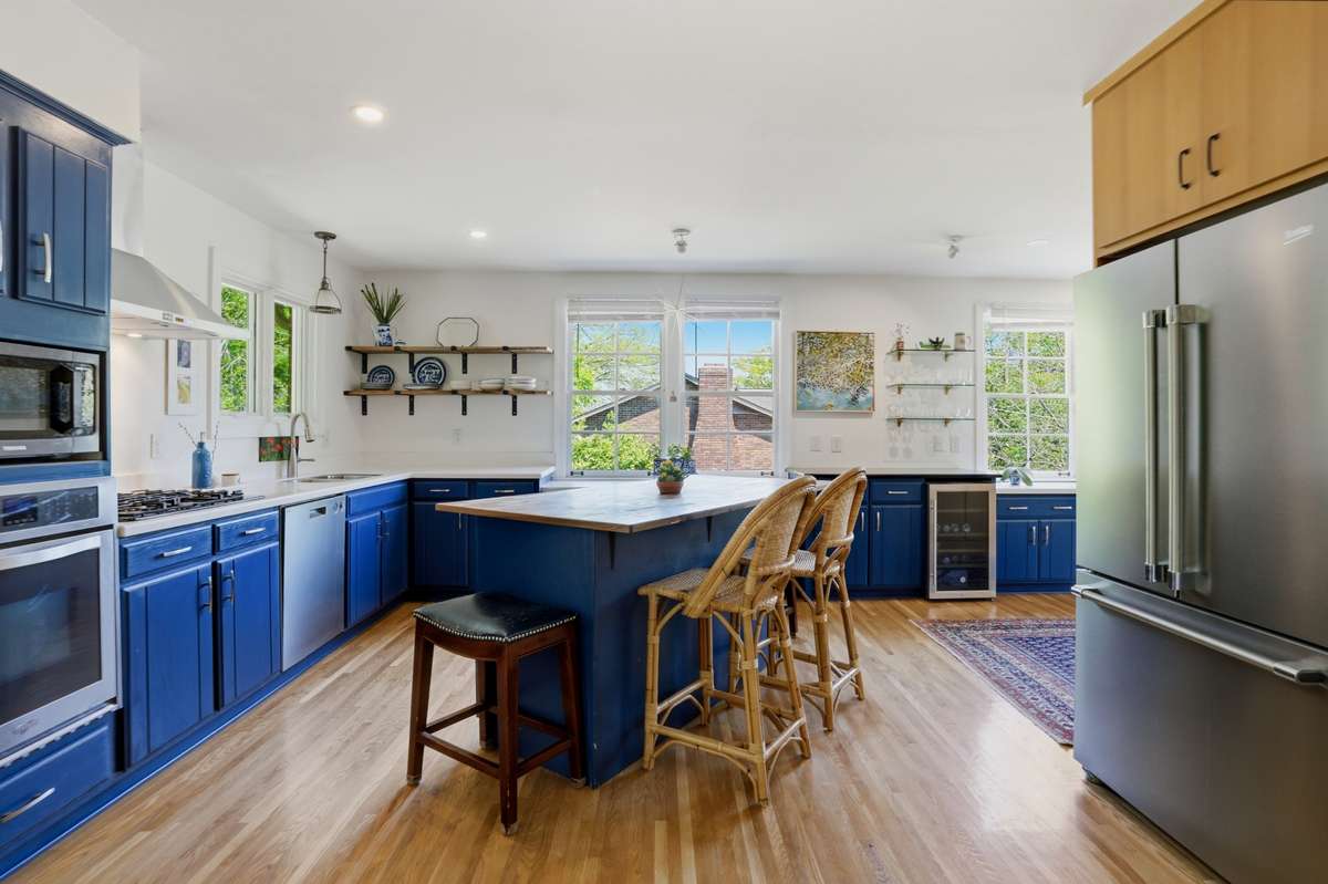 Large, open kitchen with stainless appliances, tons of natural light, beverage refrigerator, eat-in island and open to dining.