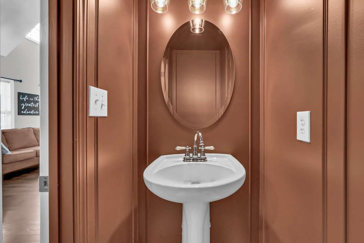 Half bath on main level has been color drenched + updated modern lighting.