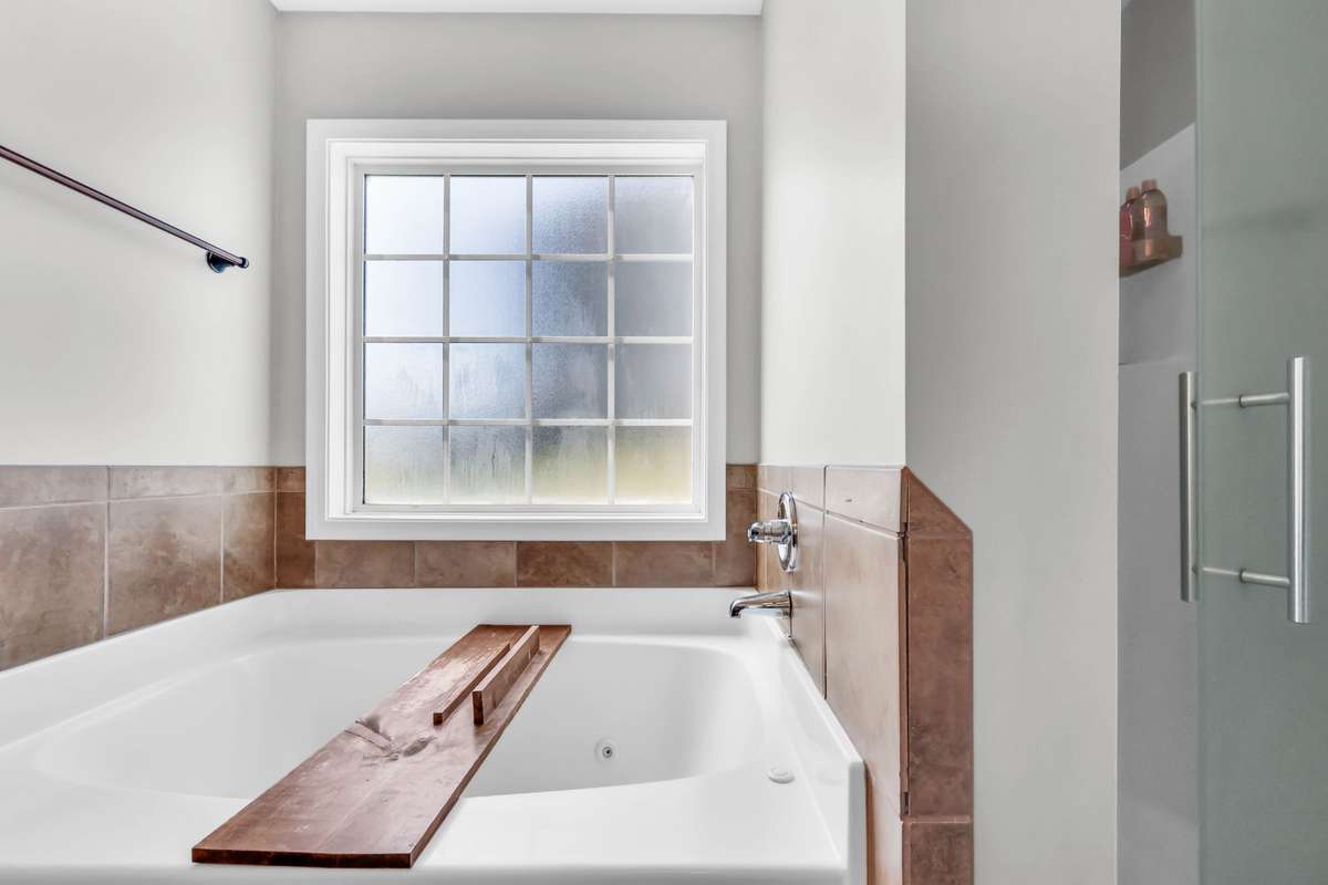 Jetted soaking tub + separate show with glass door.