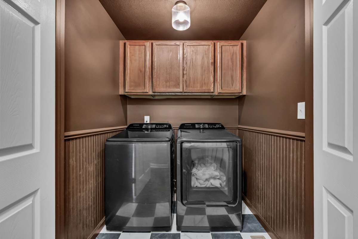 Laundry closet on main level features tile floors + wainscoting + color drenching