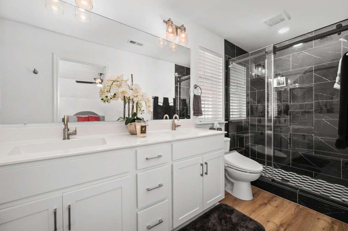 The owner's bath includes a sleek, black, walk-in shower, double vanities and a separate tub.