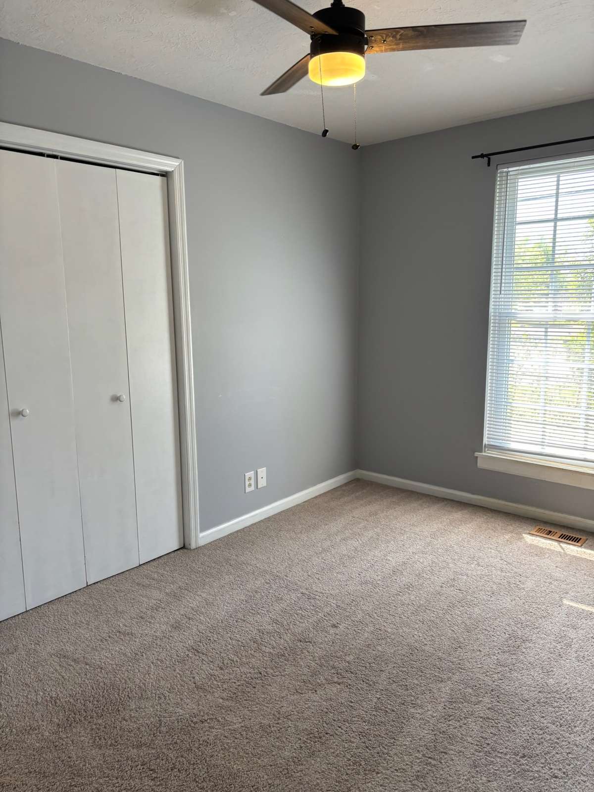 Back bedroom with ceiling fan. Double sized closet with selves.