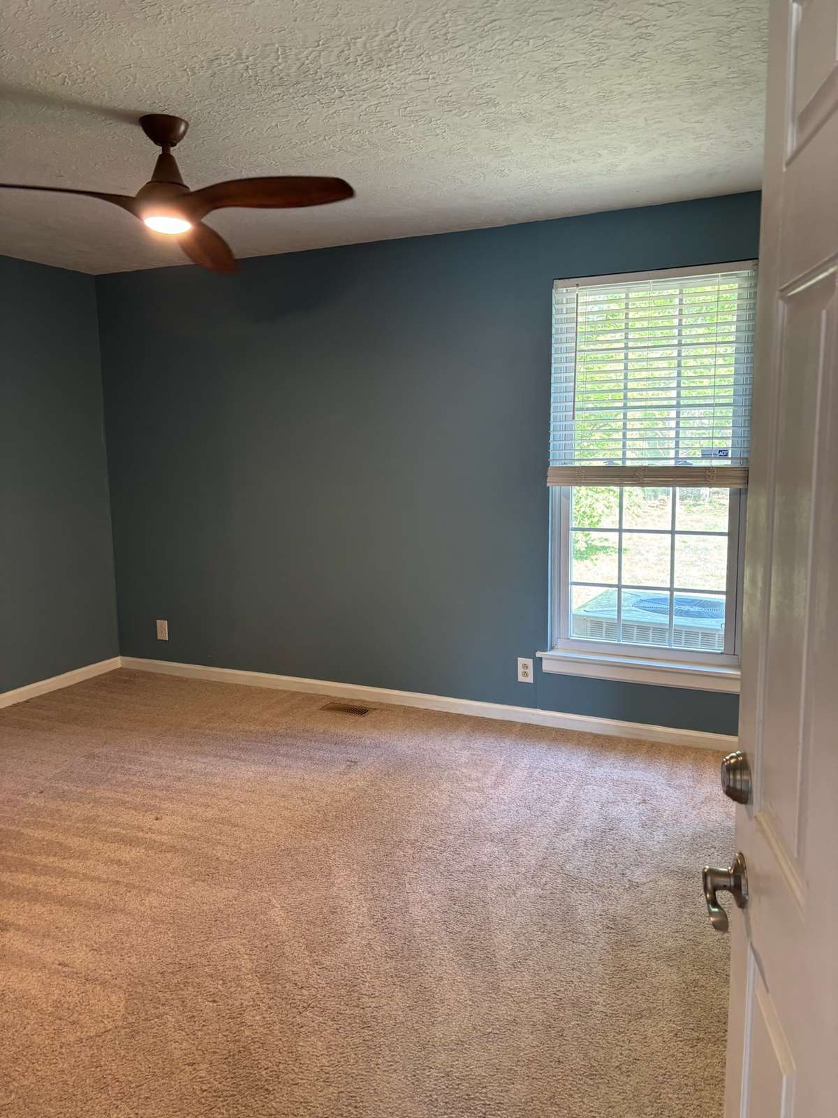 Primary bedroom with ceiling fan.