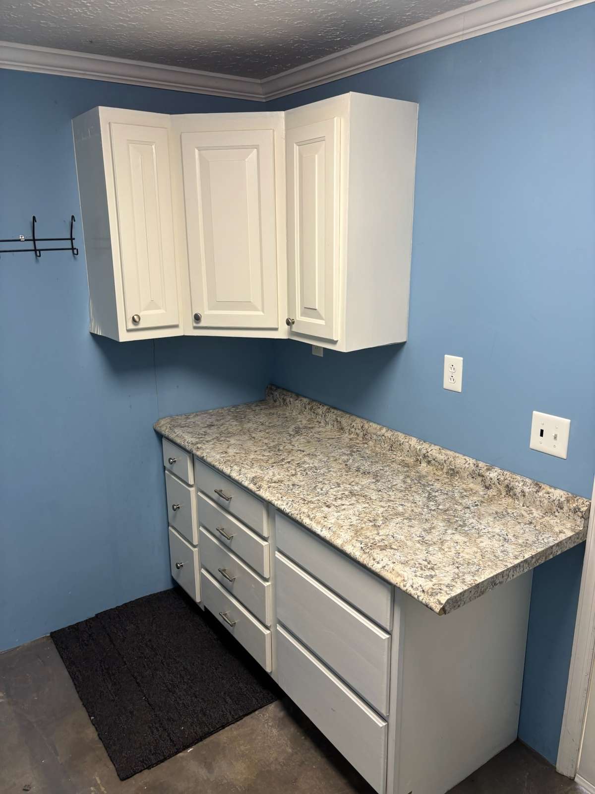 Laundry room with cabinets and washer and dryer hookups.