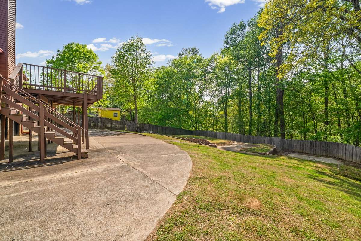 View of Backyard and concrete circular driveway.