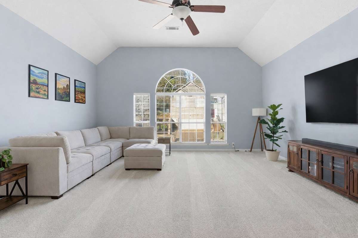 Massive bonus room with vaulted ceilings, oversized arched windows, and abundant natural light. Plush new carpet and flexible layout make this an ideal media room, playroom, or second living space. - Art digitally added