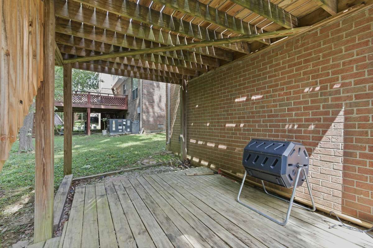 Private two-level back deck offering a comfortable, usable outdoor space—ideal for relaxing, entertaining, or enjoying quiet moments surrounded by mature greenery.