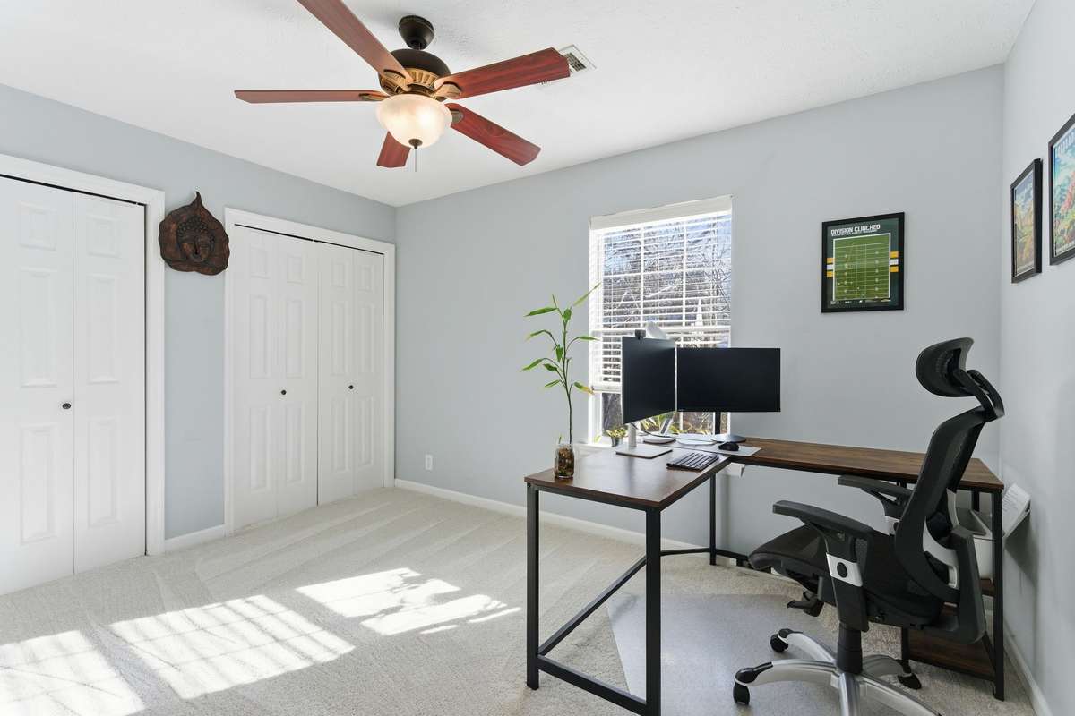 Bright second bedroom with plush carpet, ceiling fan, and generous closet space—ideal for a guest room, home office, or flex space with natural light and a quiet second-level setting.