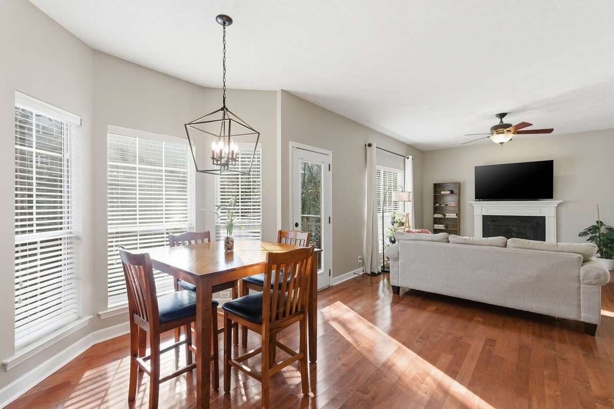 Sunlit breakfast nook with oversized windows and warm hardwood floors, offering a bright, inviting space for casual meals, morning coffee, or a cozy dining area just off the kitchen.