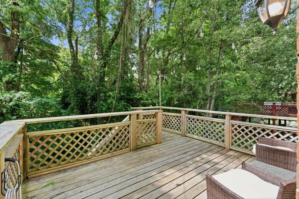 Private two-level back deck offering a comfortable, usable outdoor space—ideal for relaxing, entertaining, or enjoying quiet moments surrounded by mature greenery.