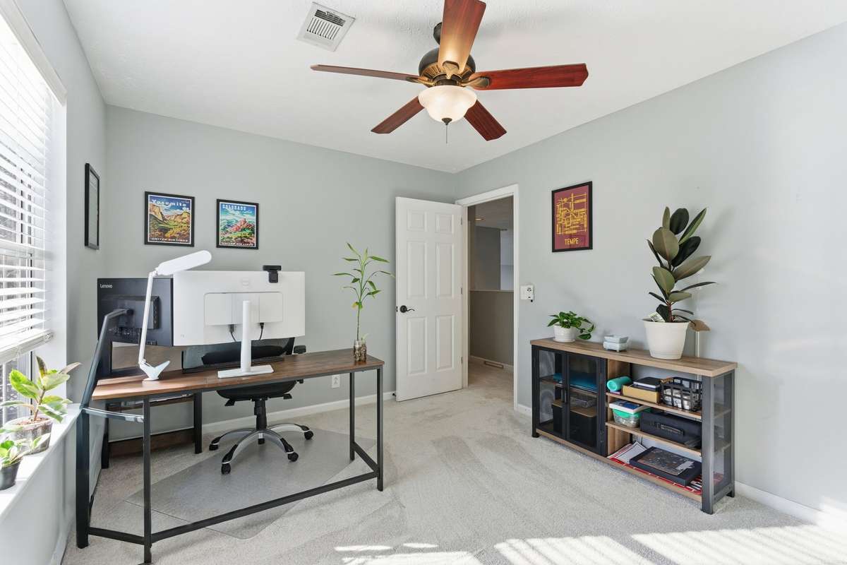 Bright second bedroom with plush carpet, ceiling fan, and generous closet space—ideal for a guest room, home office, or flex space with natural light and a quiet second-level setting.