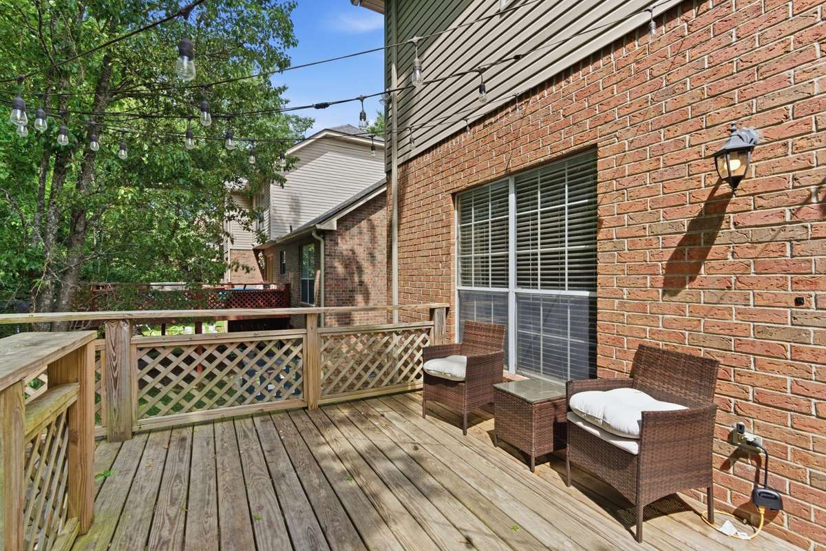 Private two-level back deck offering a comfortable, usable outdoor space—ideal for relaxing, entertaining, or enjoying quiet moments surrounded by mature greenery.