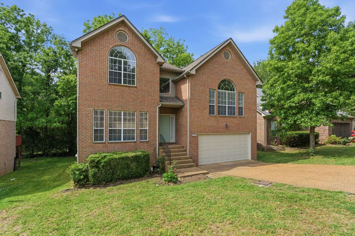 Beautiful brick two-story home with timeless curb appeal, oversized windows, and a welcoming front entry.