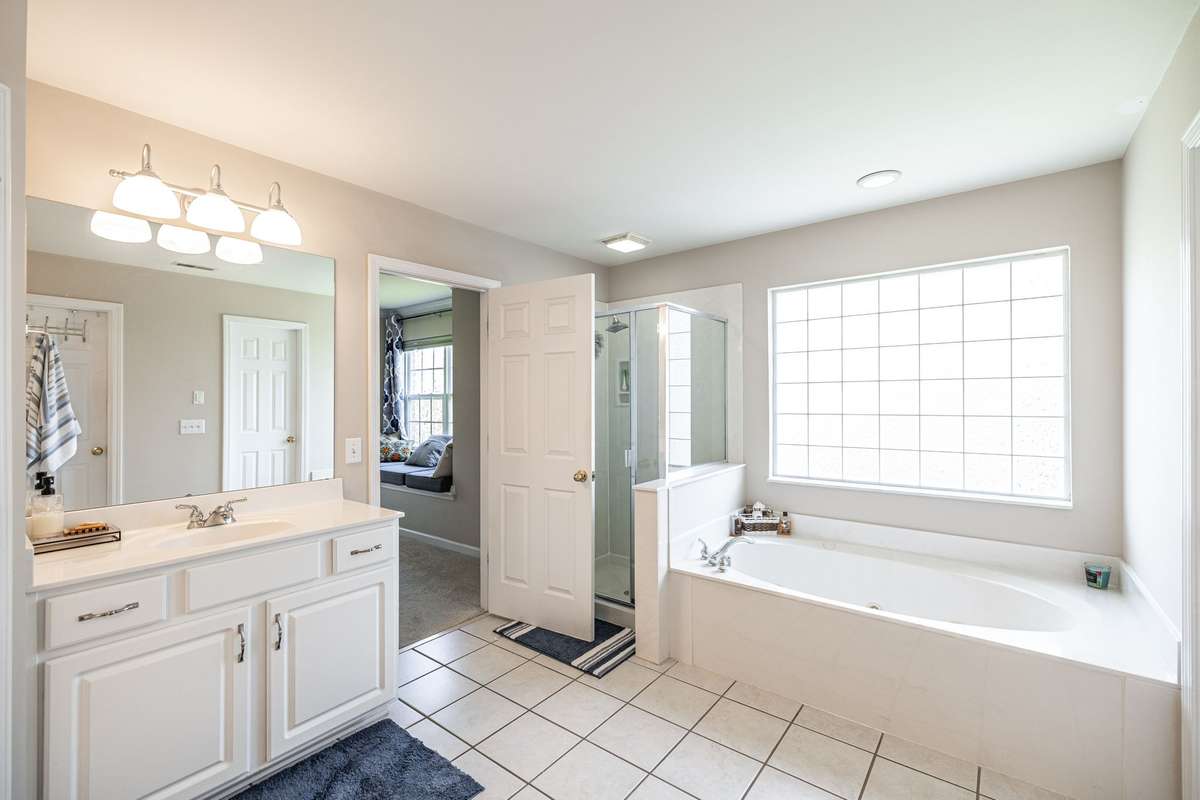 Primary bathroom with separate shower / spa tub and separate vanities