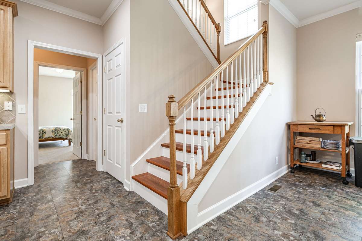 Stairway to upstairs and door to downward stairs accessing basement