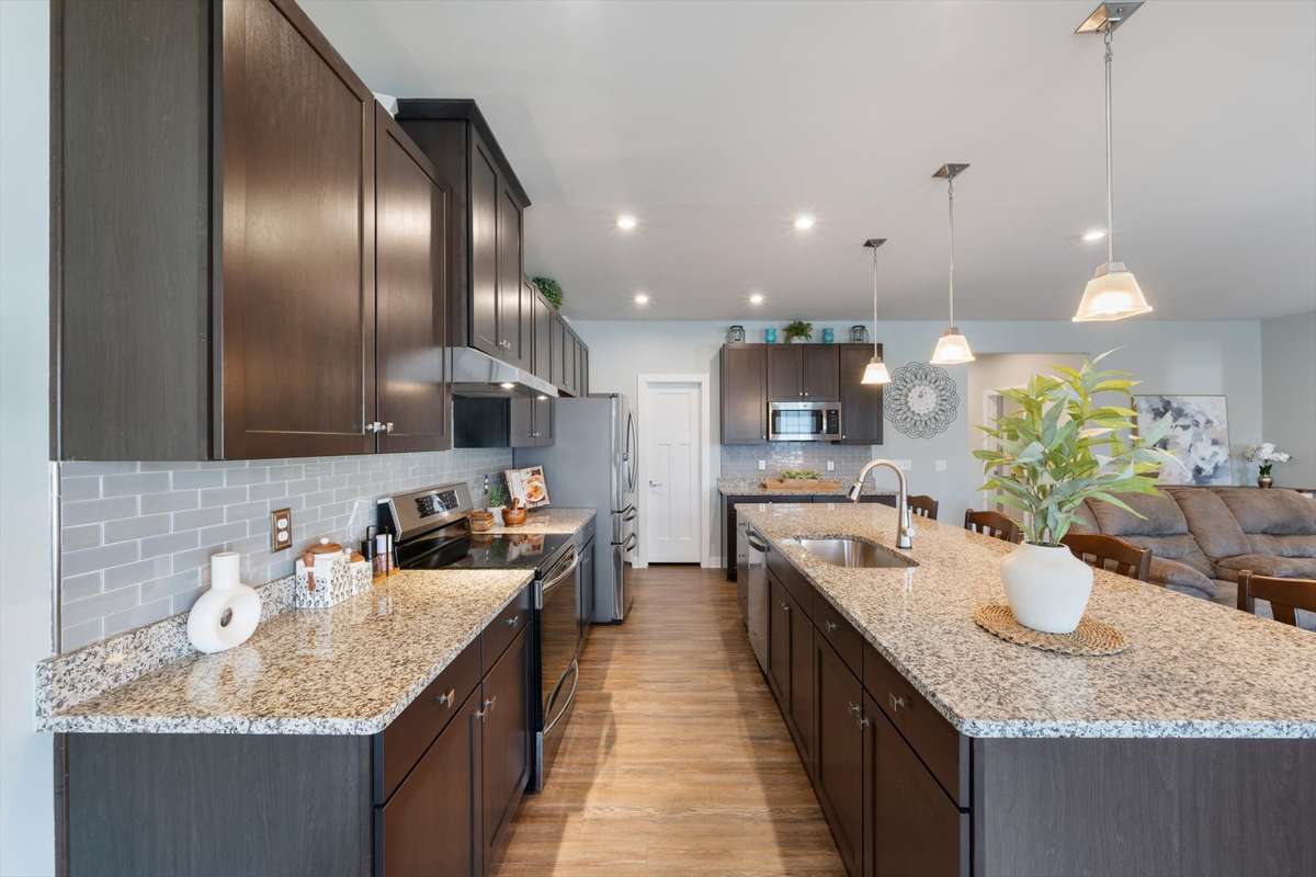 There is no shortage of work space in this kitchen!  Low-maintenance granite counters top gorgeous cabinets with abundant storage.  The glass tile backsplash is a beautiful upgrade that defines and elevates the space.